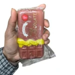 Chocolate bar-shaped squishy novelty toys in brown, pink and cream, individually wrapped and displayed in a wholesale box of 12.
