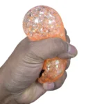 Halloween Mystery Dumpling Squishy Toy featuring an orange glitter pumpkin face, colourful mystery toy display box, 8.5cm size and £2.99 each wholesale price from SDMAX Toys Wholesaler.