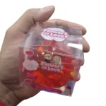 Flowers of Love rose-shaped novelty squeeze toys in red, blue, yellow and purple, displayed in a pink box of 12 by SDMAX Toys Wholesaler.